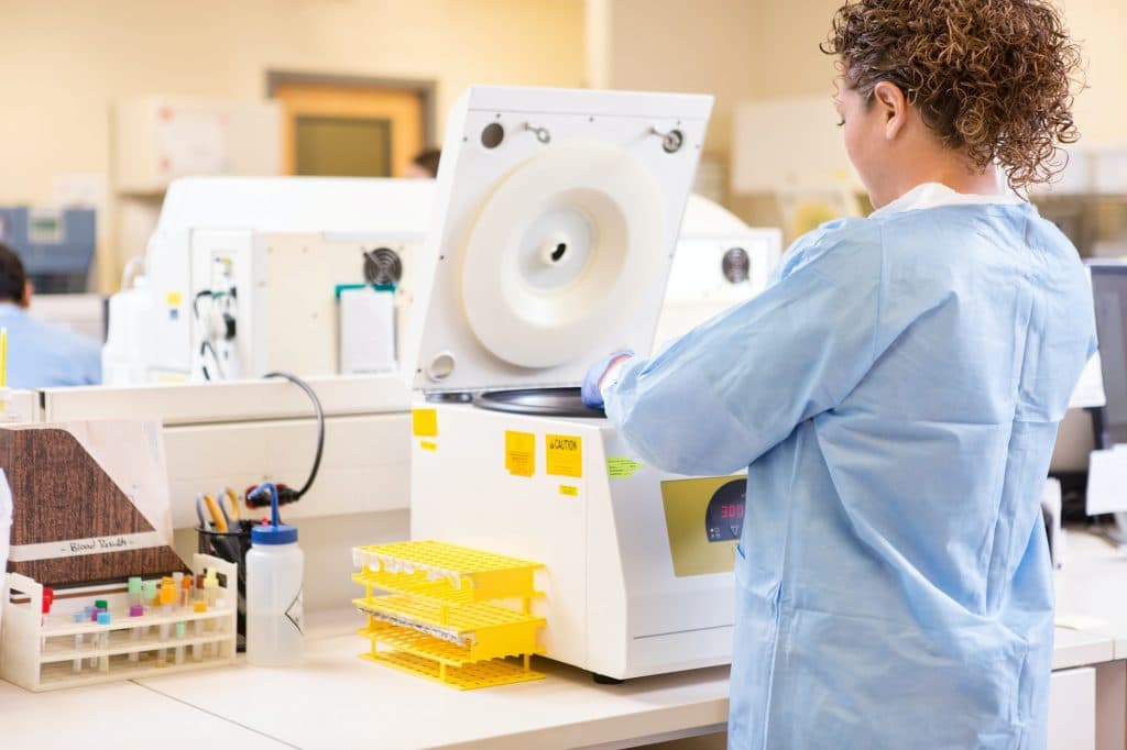 Scientist Using PCR Machine In Laboratory